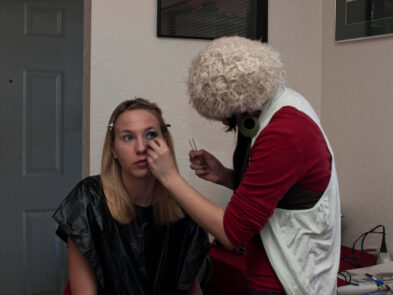 Makeup artist Stefanie applies colorful eye makeup to model Anne during preparations for the Octopus Project photo shoot.