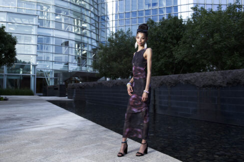 Full-length portrait of Bratzdoll standing beside the reflecting pool at Devon Tower in downtown Oklahoma City.