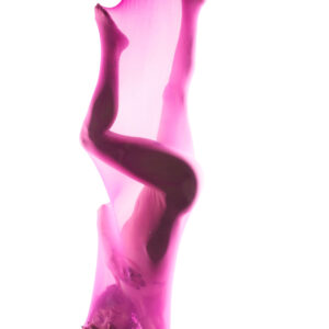 Nikki Haze poses suspended upside down inside translucent pink stretch fabric, her body forming a sculptural silhouette against a bright white background.